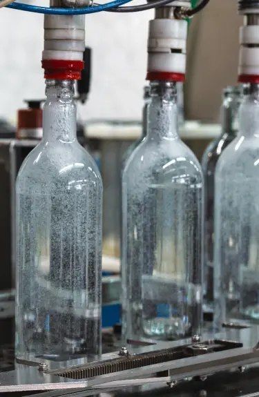 szklane butelki na taśmie produkcyjnej - producent alkoholi Toruńskie Wódki Gatunkowe